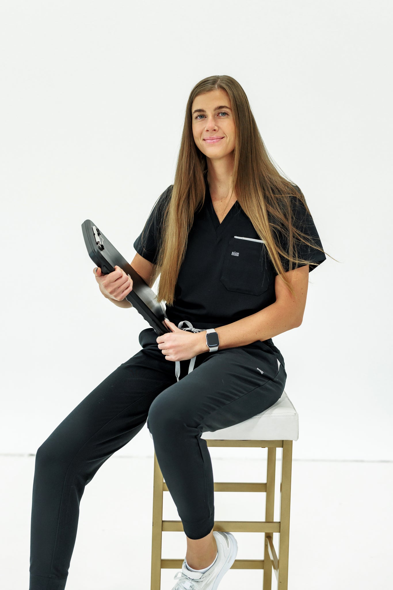 Black V-neck scrub top combining comfort, style, and durability for healthcare environments.