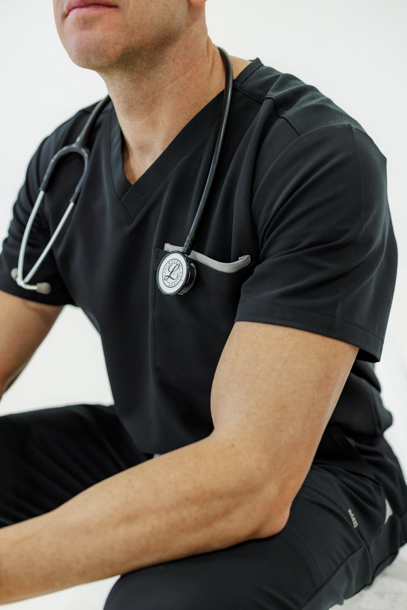 Black V-neck scrub top offering all-day comfort and a polished, professional appearance.